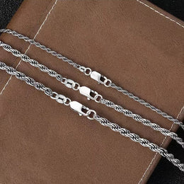 Close-up of rope chain links and lobster clasps on brown leather
