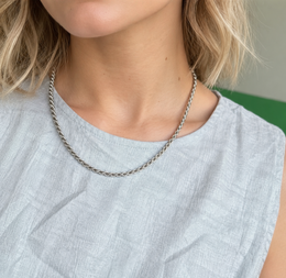 Model wearing a silver-tone rope chain over a light patterned top