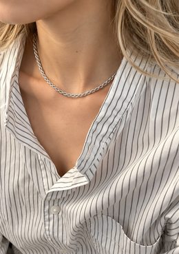 Model wearing a silver-tone rope chain with an open striped shirt