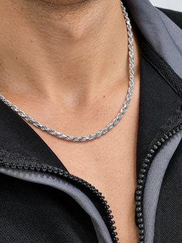 Close-up of a silver-tone rope chain worn with a black zip collar