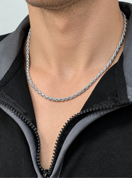 Silver-tone rope chain worn at the neck above a black zip collar
