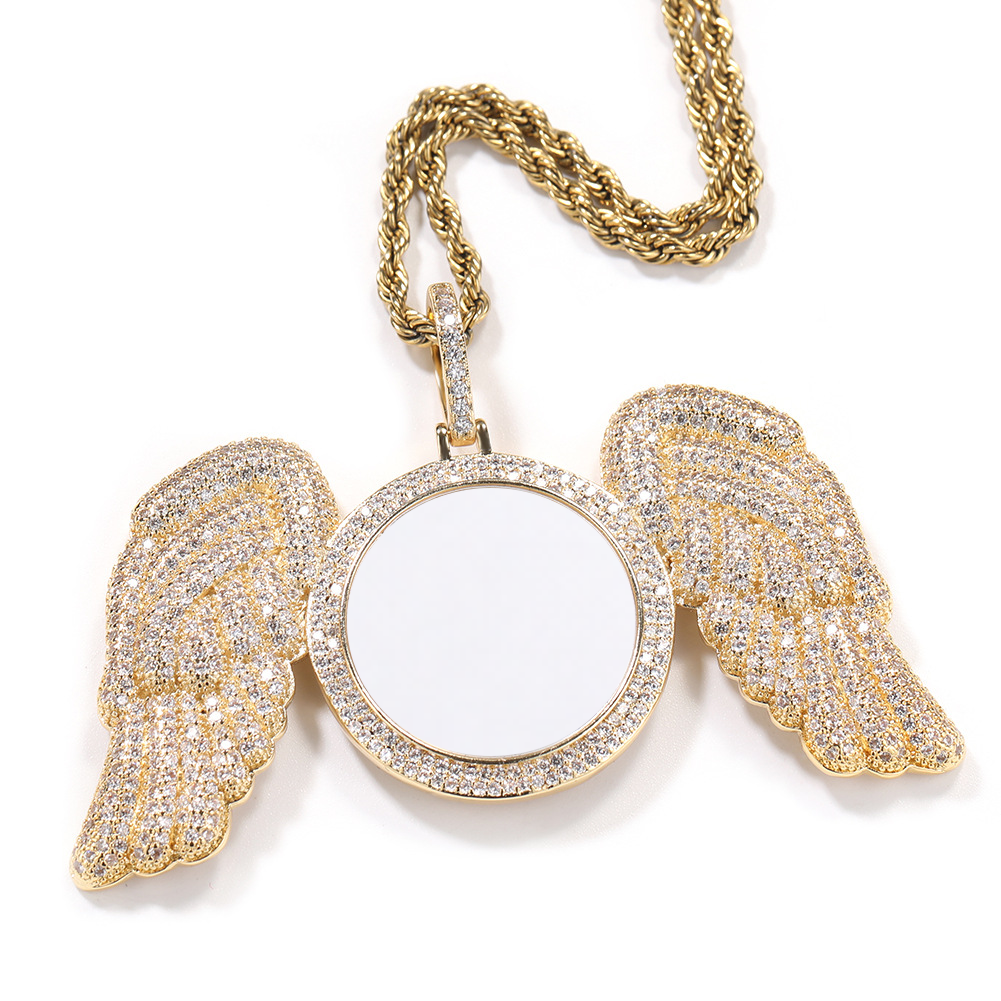 Gold-tone angel wings photo pendant with a round photo area, angled front view