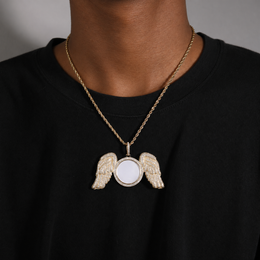 Gold-tone angel wings photo pendant worn over a black shirt
