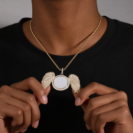 Close view of a gold-tone angel wings photo pendant held at the chest