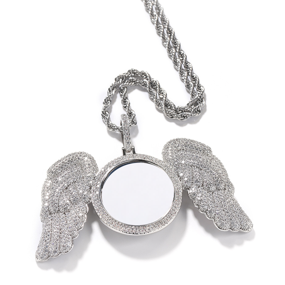 Silver-tone photo pendant showing the feather-shaped wings and stone-set frame