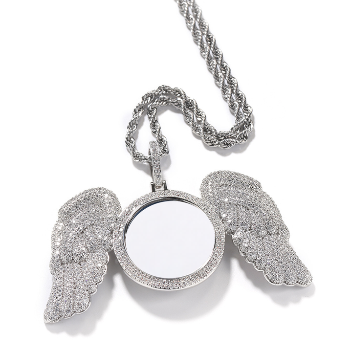 Silver-tone photo pendant showing the feather-shaped wings and stone-set frame
