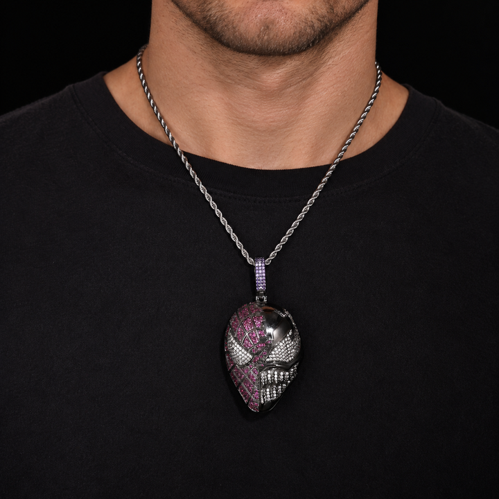 Model wearing a dark silver-tone mask pendant with pink and clear stones over a black shirt