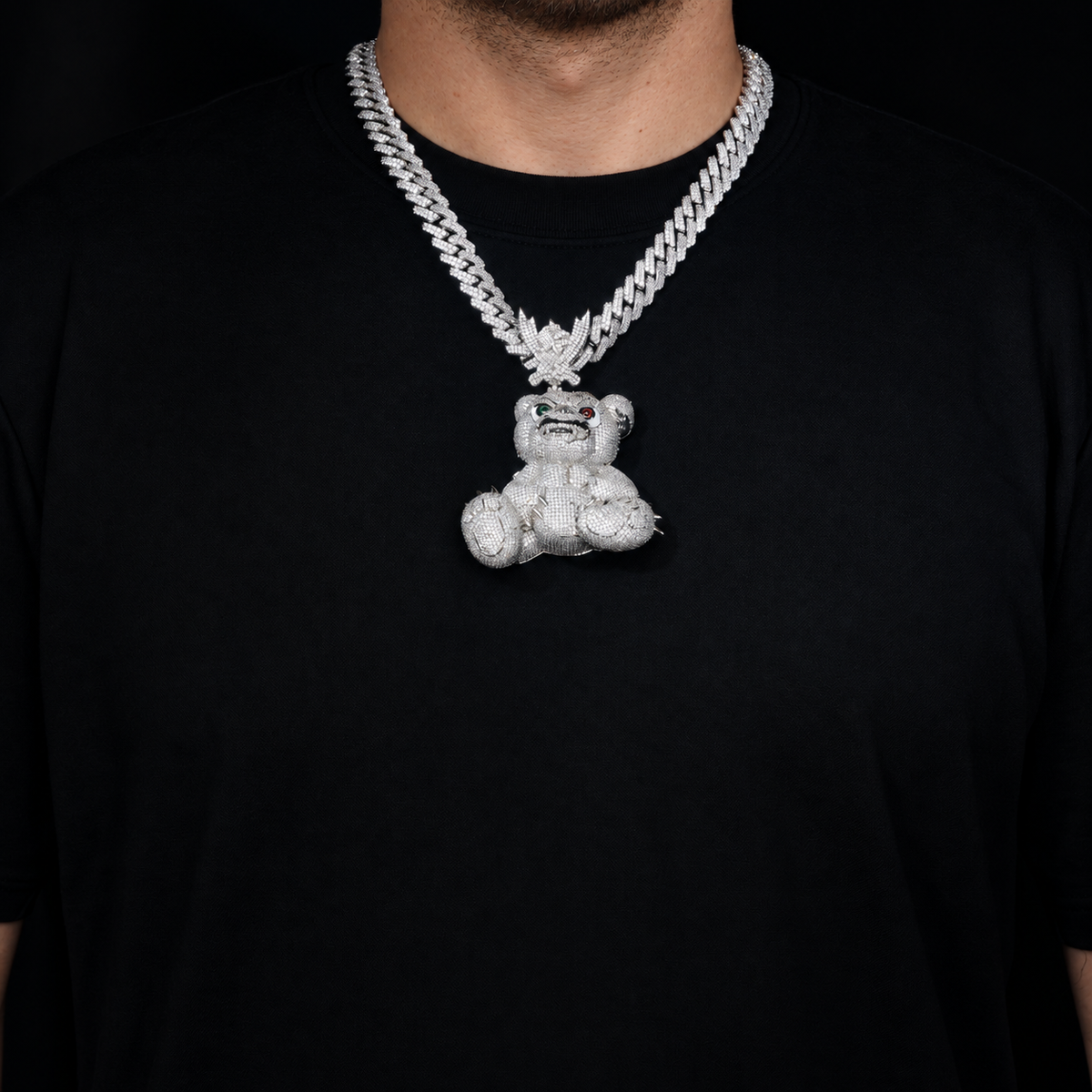 Adult model wearing the silver-tone bear pendant over a black crew-neck shirt