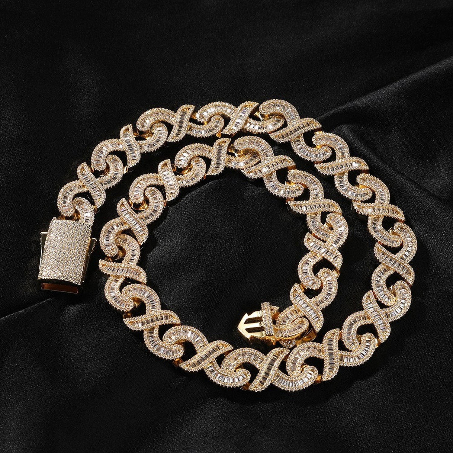 Gold 15mm infinity link necklace coiled on black fabric