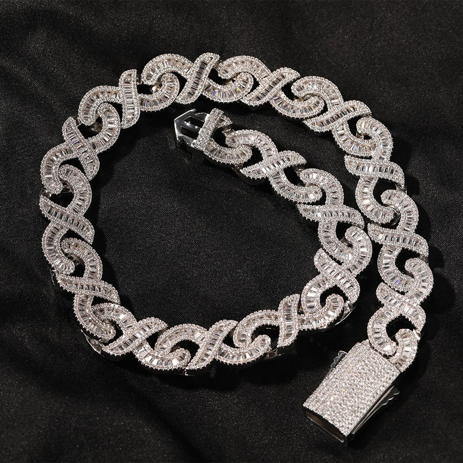 Silver 15mm infinity link necklace coiled on black fabric