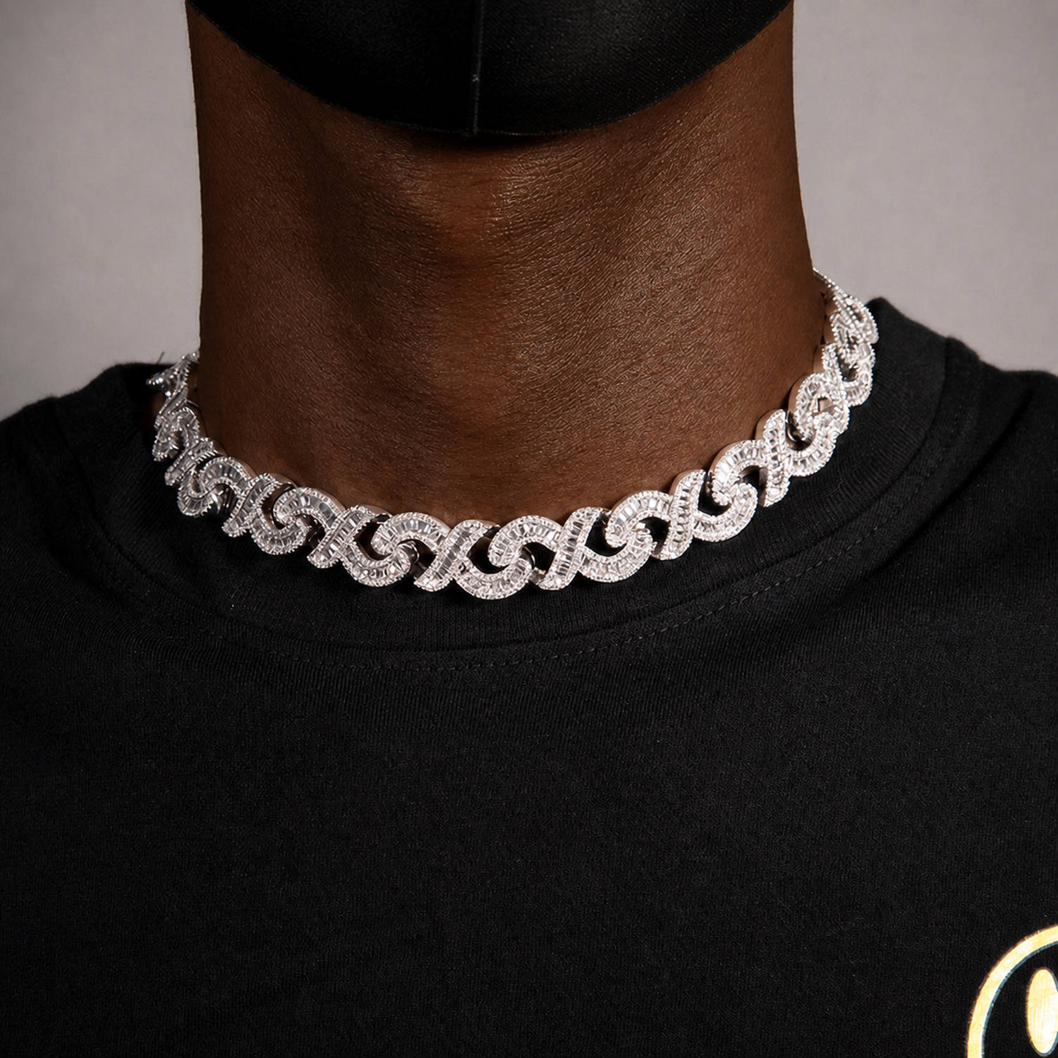Silver infinity link necklace worn by a deep-brown model