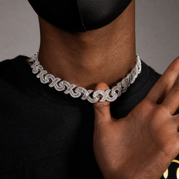 Deep-brown model holding a silver infinity link necklace