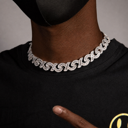 Deep-brown model pointing to a silver infinity link necklace