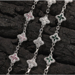 Silver-tone four-leaf clover necklace link and stone detail