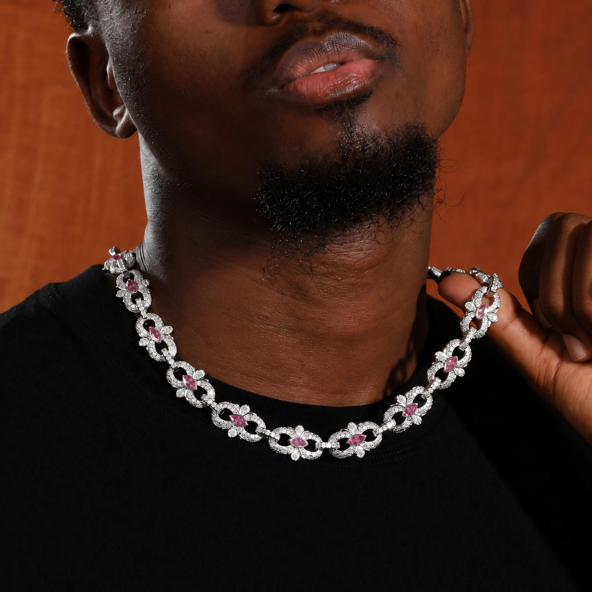 Pink marquise floral link necklace worn over a black shirt and held at one side