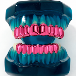 Close-up of glossy pink grillz on a blue dental display model