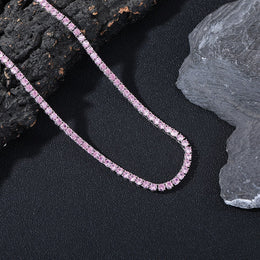 Dark-background detail view of 4mm iced pink CZ tennis chain necklace