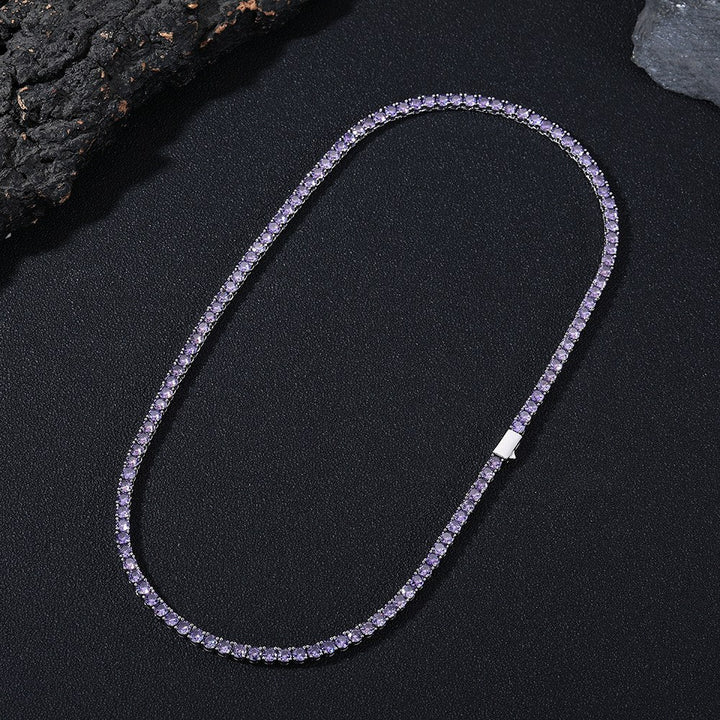 Purple-stone tennis necklace arranged in an oval beside dark rocks