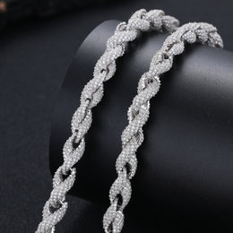 Close view of twisted stone-set rope links draped across a dark display cushion