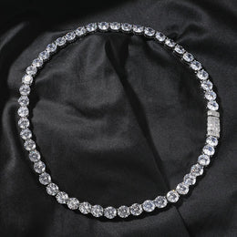 Silver-tone tennis chain arranged in a circle with its rectangular-stone box clasp closed