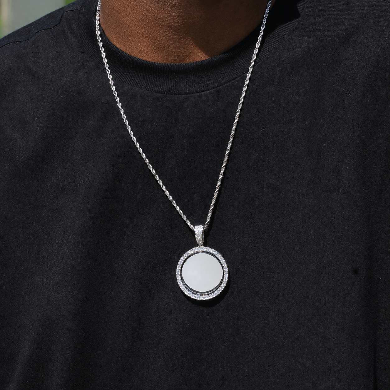 Silver-tone pendant with a white photo-customization area worn over a black shirt