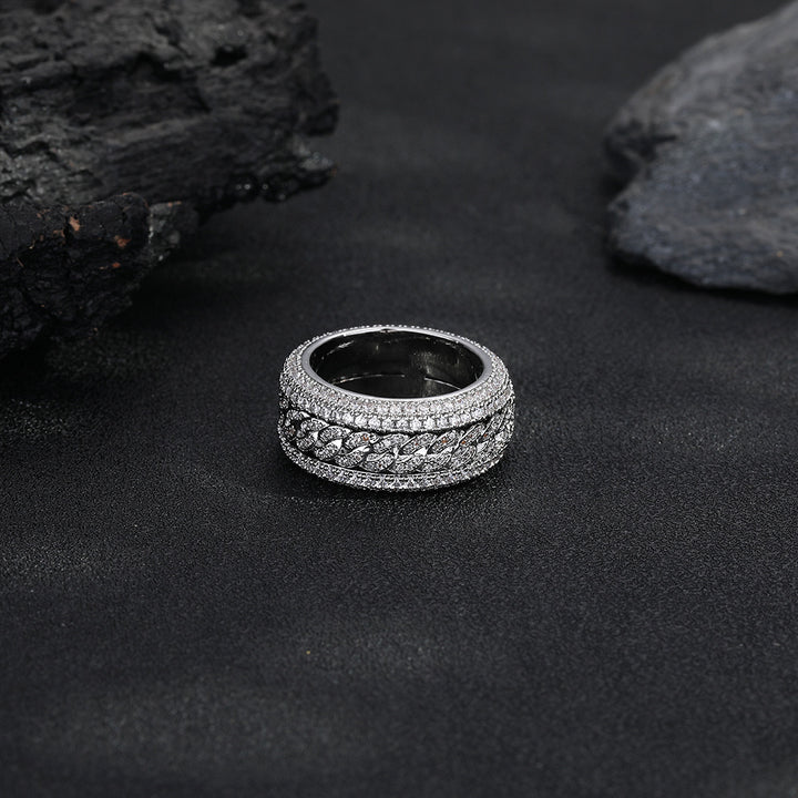 Silver-tone Cuban link ring lying flat on a dark surface