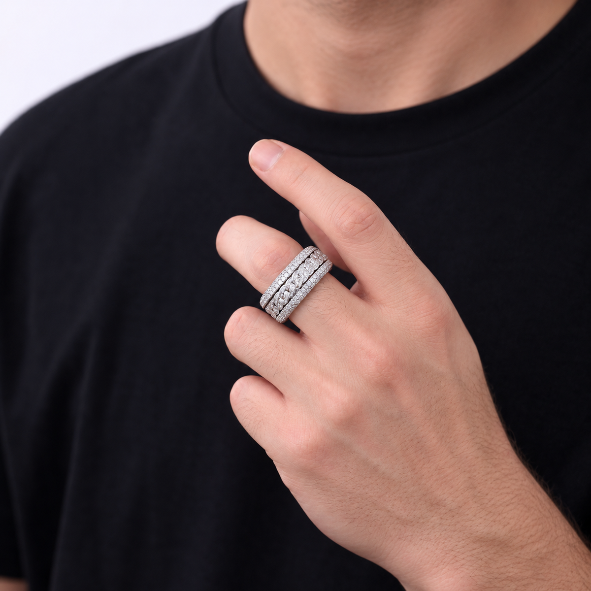 Adult wearing a silver-tone Cuban link ring with a black shirt