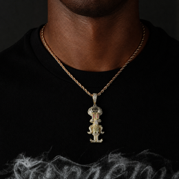 Gold iced cartoon squid character pendant worn by a deep-brown model