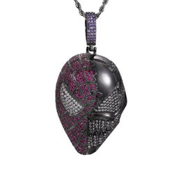 Dark silver-tone fanged mask pendant with pink and clear stones and a purple bail on white