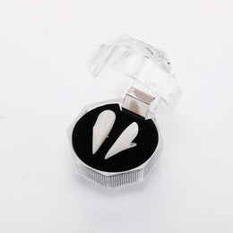 White vampire fangs in an open clear hinged display box