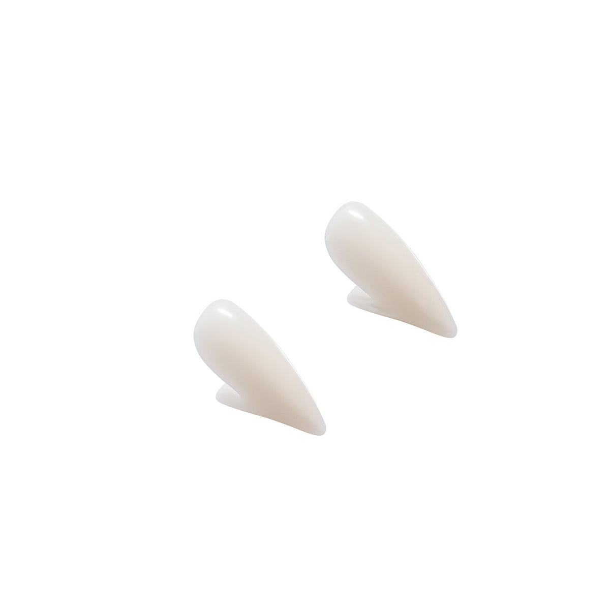 Pair of white vampire fang caps viewed from the side