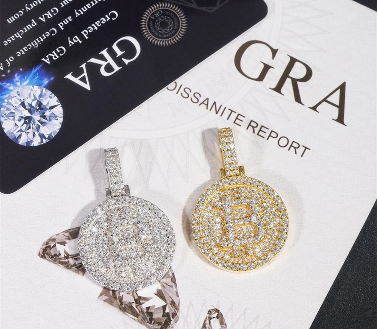 Iced pendants displayed with a GRA moissanite report and certificate card